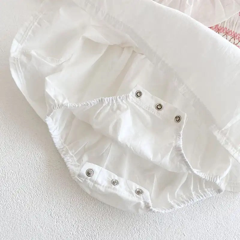 White romper with pink embroidery detail