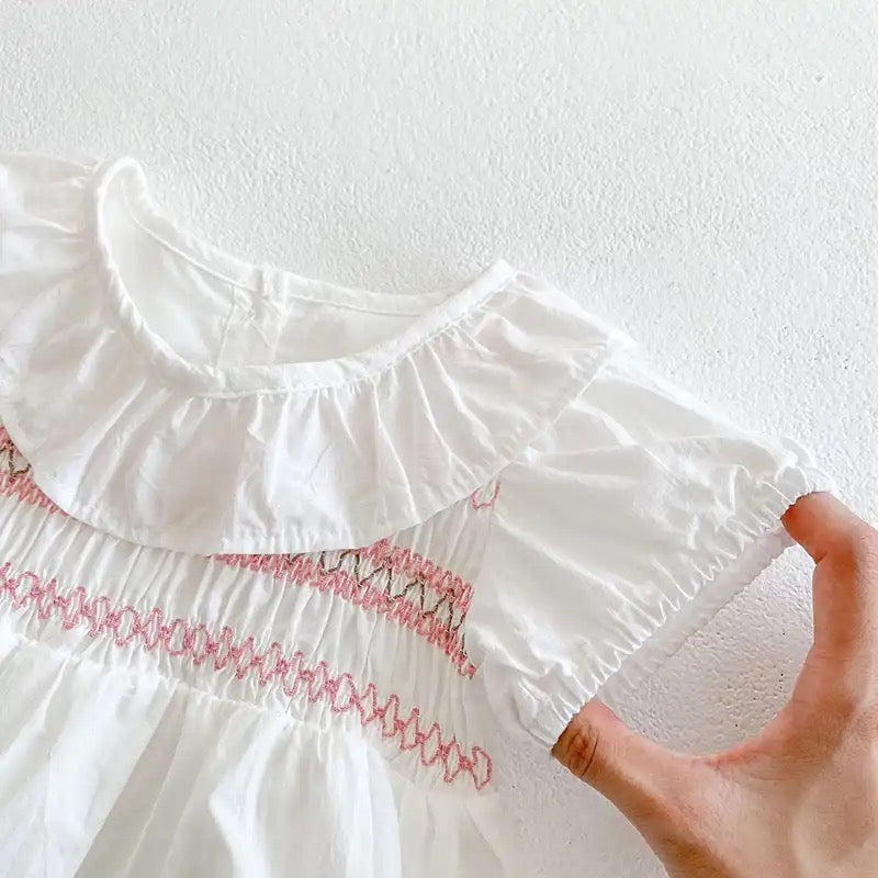 White romper with pink embroidery detail