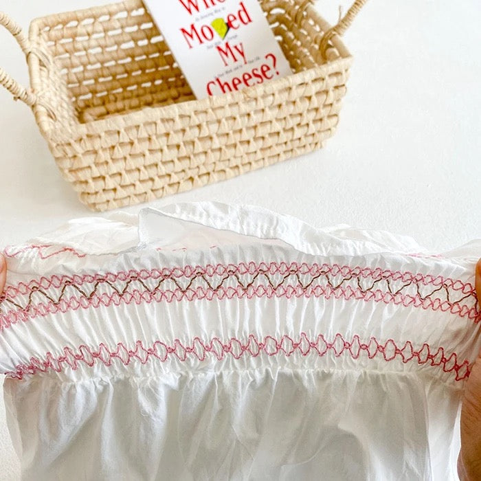 White romper with pink embroidery detail