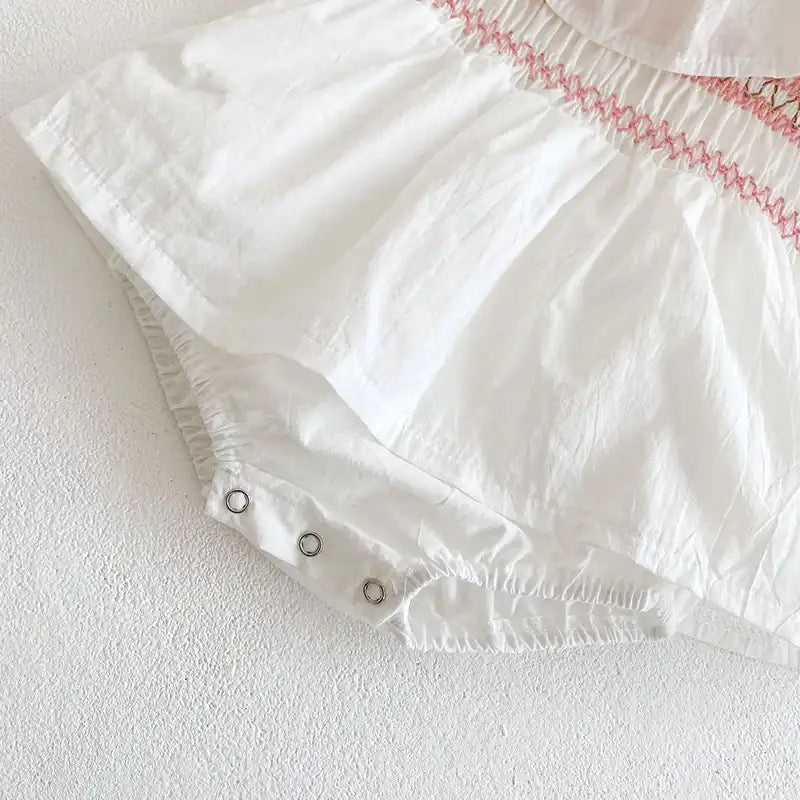 White romper with pink embroidery detail